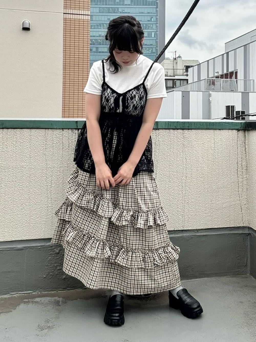 ベージュ系のスカート、ブラック系のチュニック、ホワイト系のTシャツ/カットソーを着用したレディースの夏コーディネートの8枚目の写真