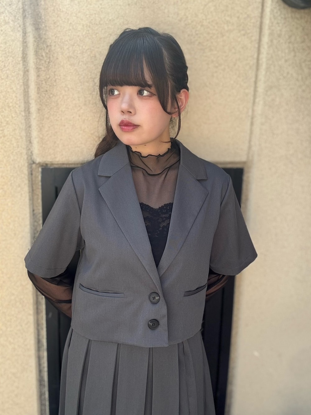 グレー系のスカート、グレー系のテーラードジャケット、ブラック系のTシャツ/カットソーを着用したレディースの春コーディネートの5枚目の写真