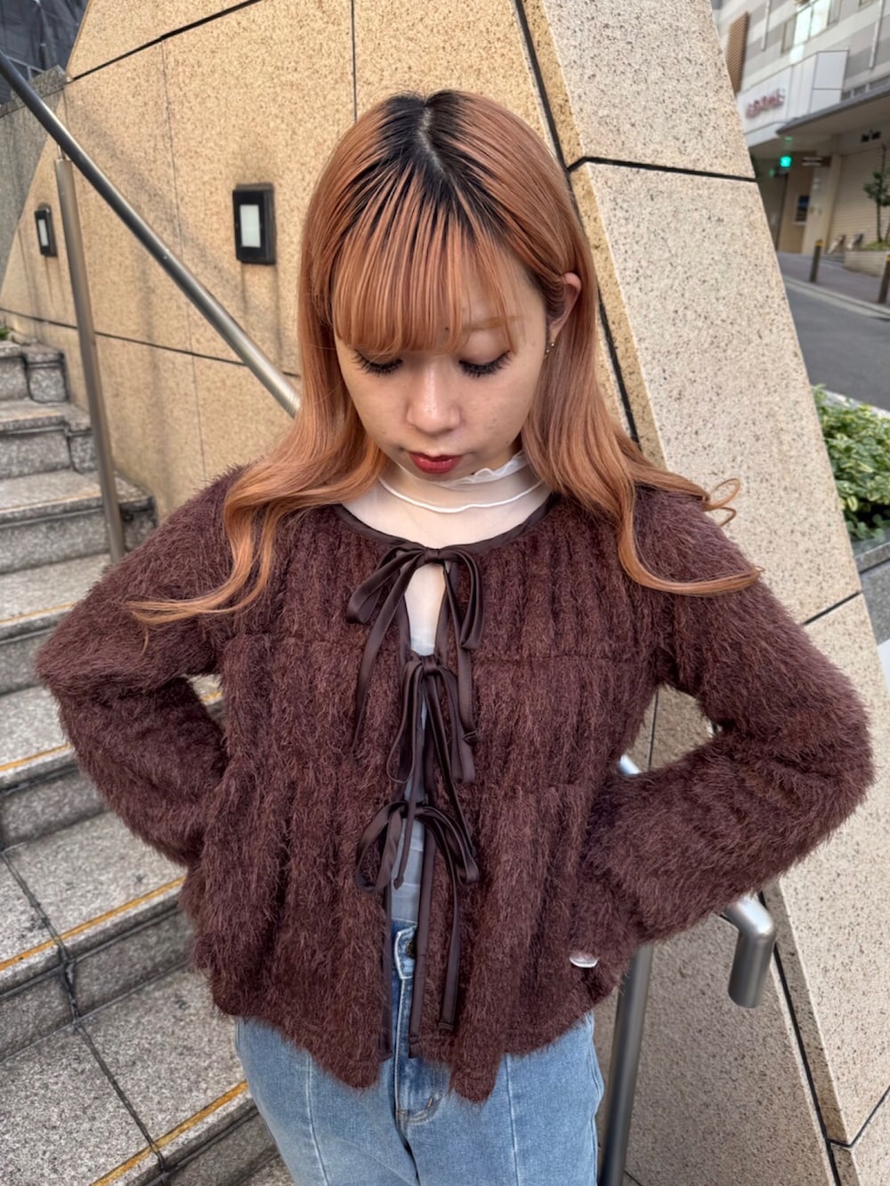 ブラウン系のカーディガン/ボレロ、ホワイト系のTシャツ/カットソー、ブルー系のデニムパンツを着用したレディースの秋コーディネートの2枚目の写真