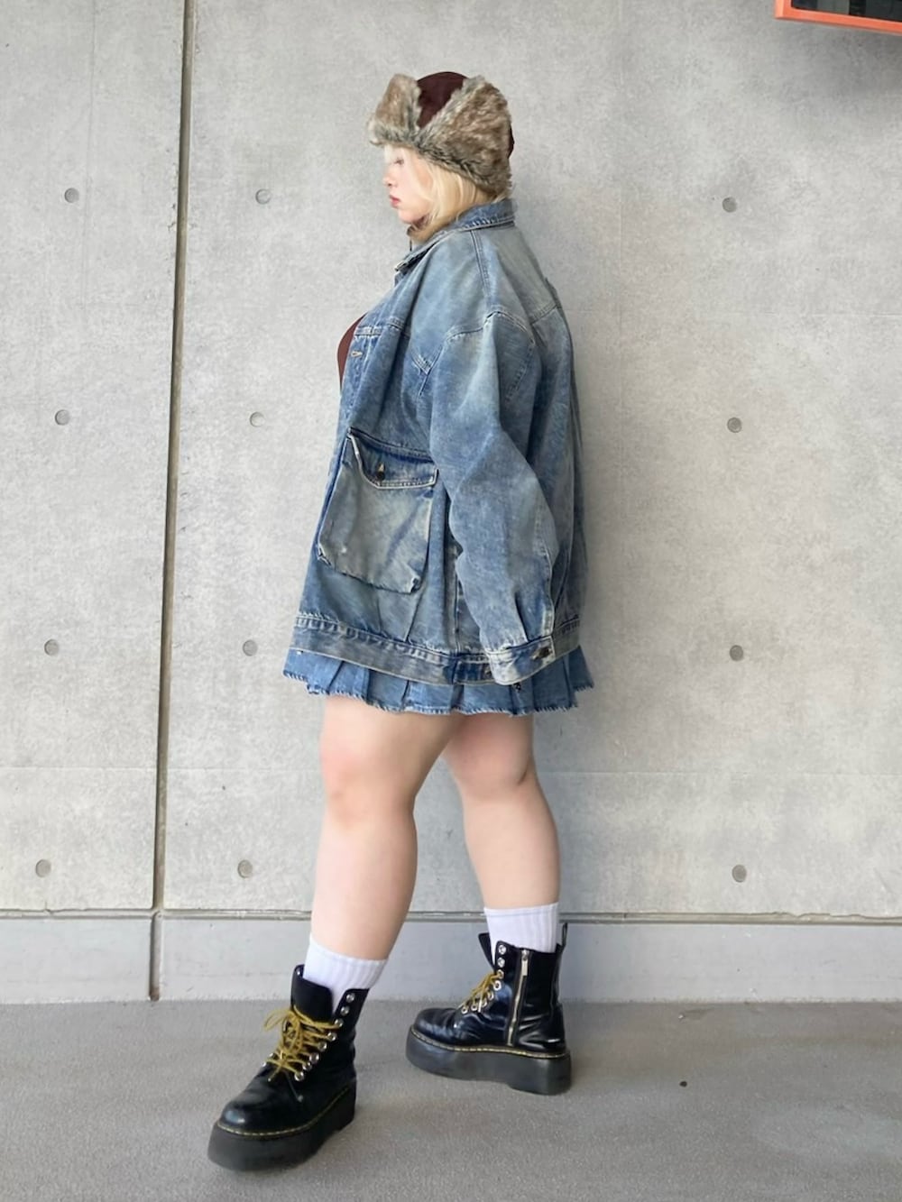 ブルー系のデニムスカート、ブルー系のデニムジャケット、ブラウン系のスウェットを着用したレディースの秋コーディネートの2枚目の写真