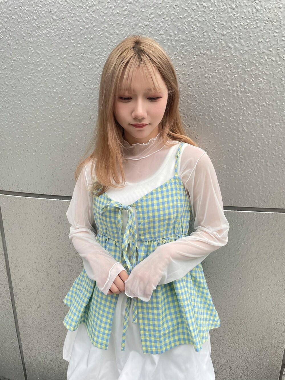 イエロー系のキャミソール、ホワイト系のスカート、ホワイト系のTシャツ/カットソーを着用したレディースの春コーディネートの3枚目の写真