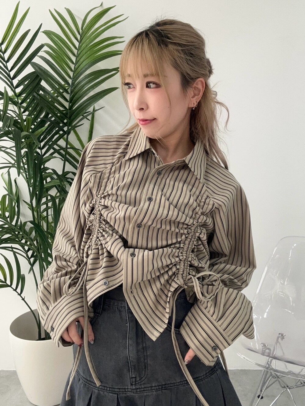 ブラック系のデニムスカート、ブラウン系のシャツ/ブラウスを着用したレディースの冬コーディネートの2枚目の写真
