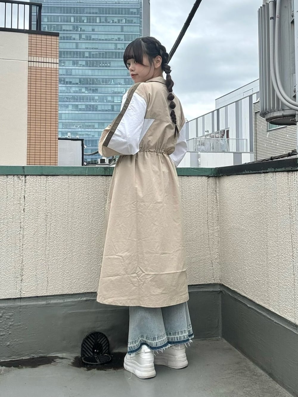 ベージュ系のワンピース、ブルー系のデニムパンツを着用したレディースの春コーディネートの4枚目の写真