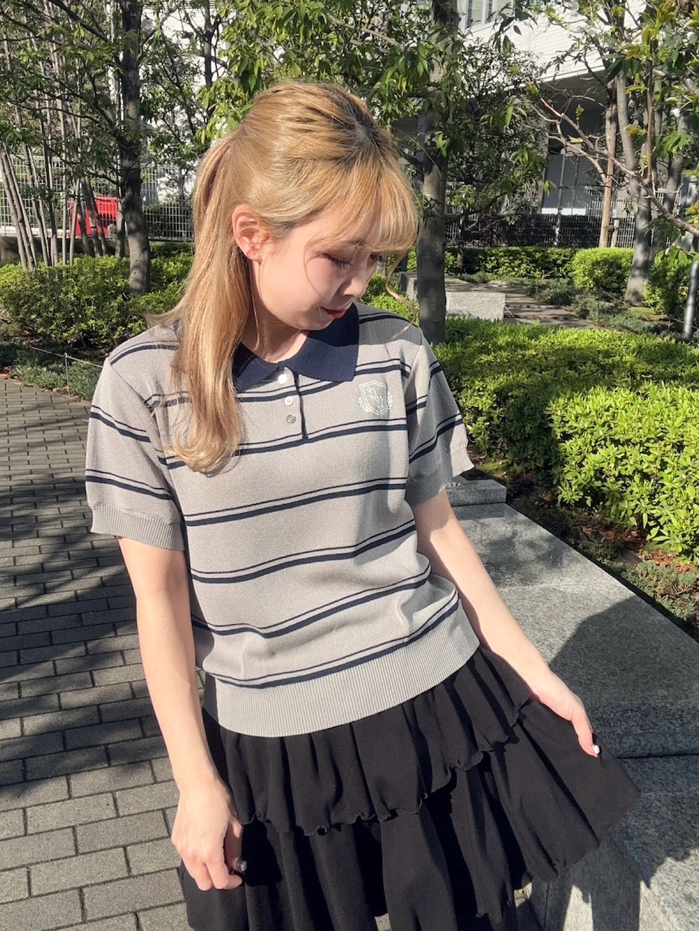 ブラック系のその他パンツ、グレー系のポロシャツを着用したレディースの春コーディネートの6枚目の写真