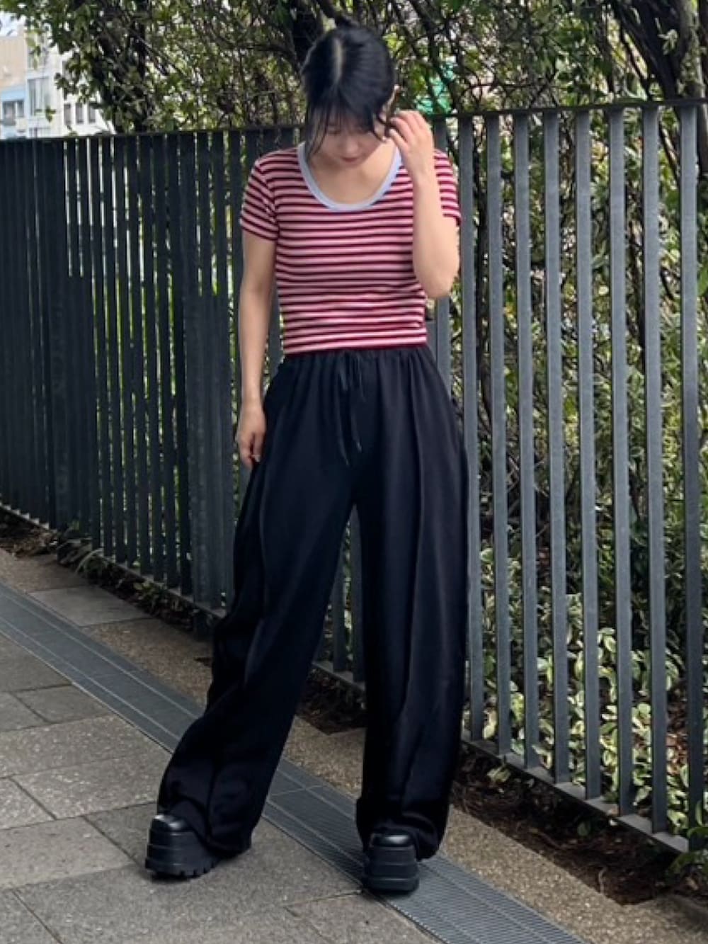ブラック系のスウェットパンツ、レッド系のTシャツ/カットソーを着用したレディースの夏コーディネートの2枚目の写真
