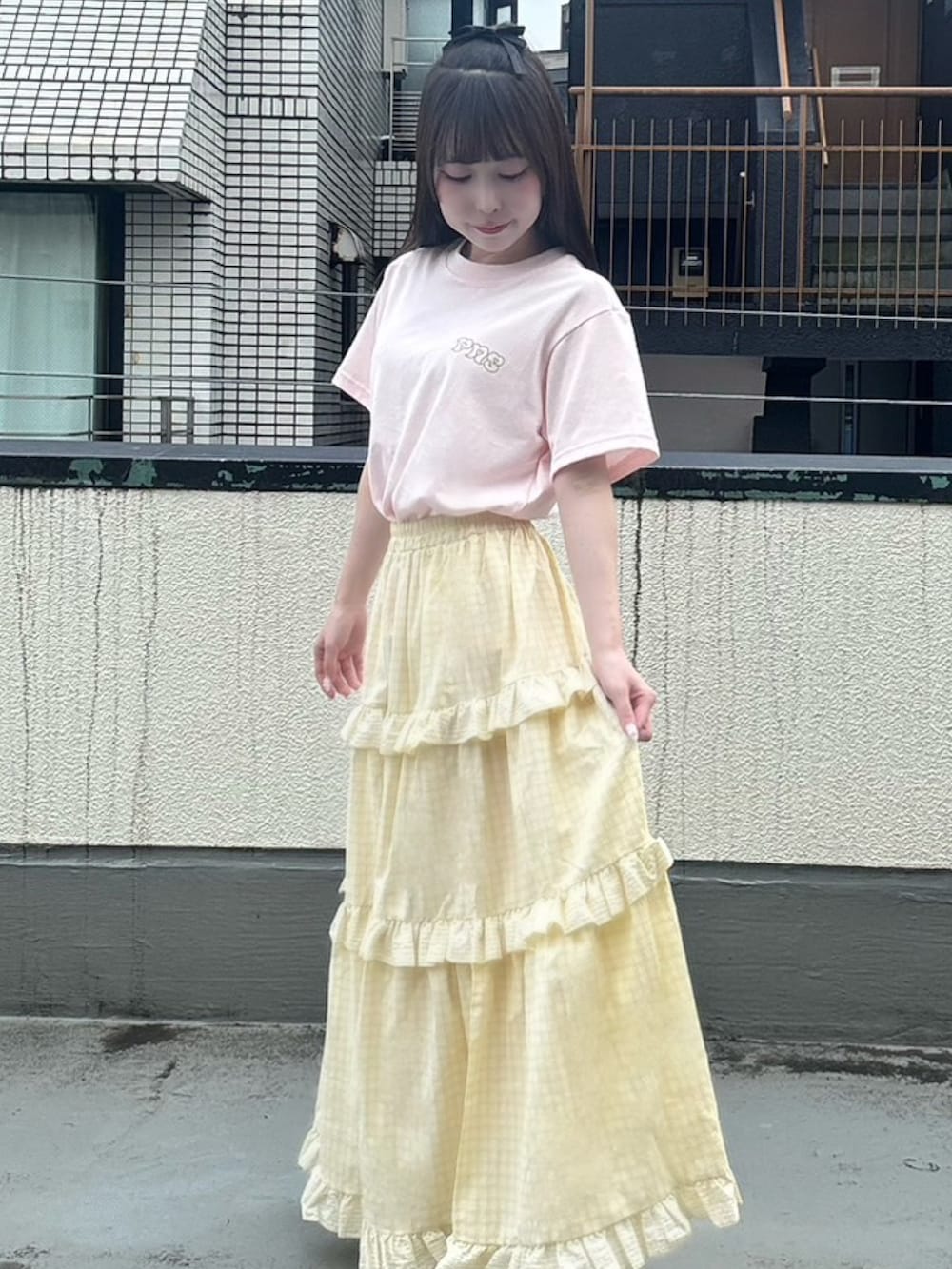イエロー系のスカート、ピンク系のTシャツ/カットソーを着用したレディースの夏コーディネートの4枚目の写真