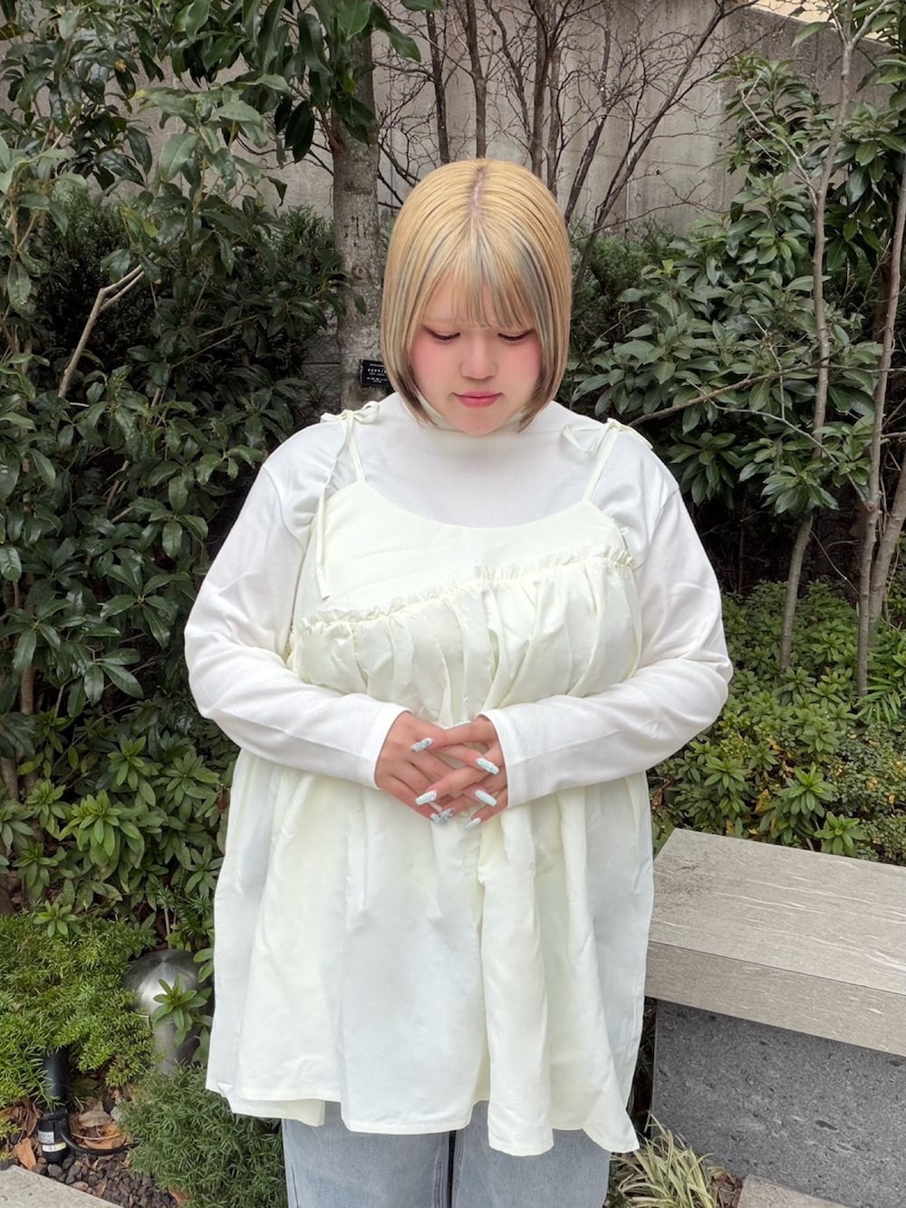 ホワイト系のワンピース、ホワイト系のTシャツ/カットソー、ブルー系のデニムパンツを着用したレディースの冬コーディネートの4枚目の写真