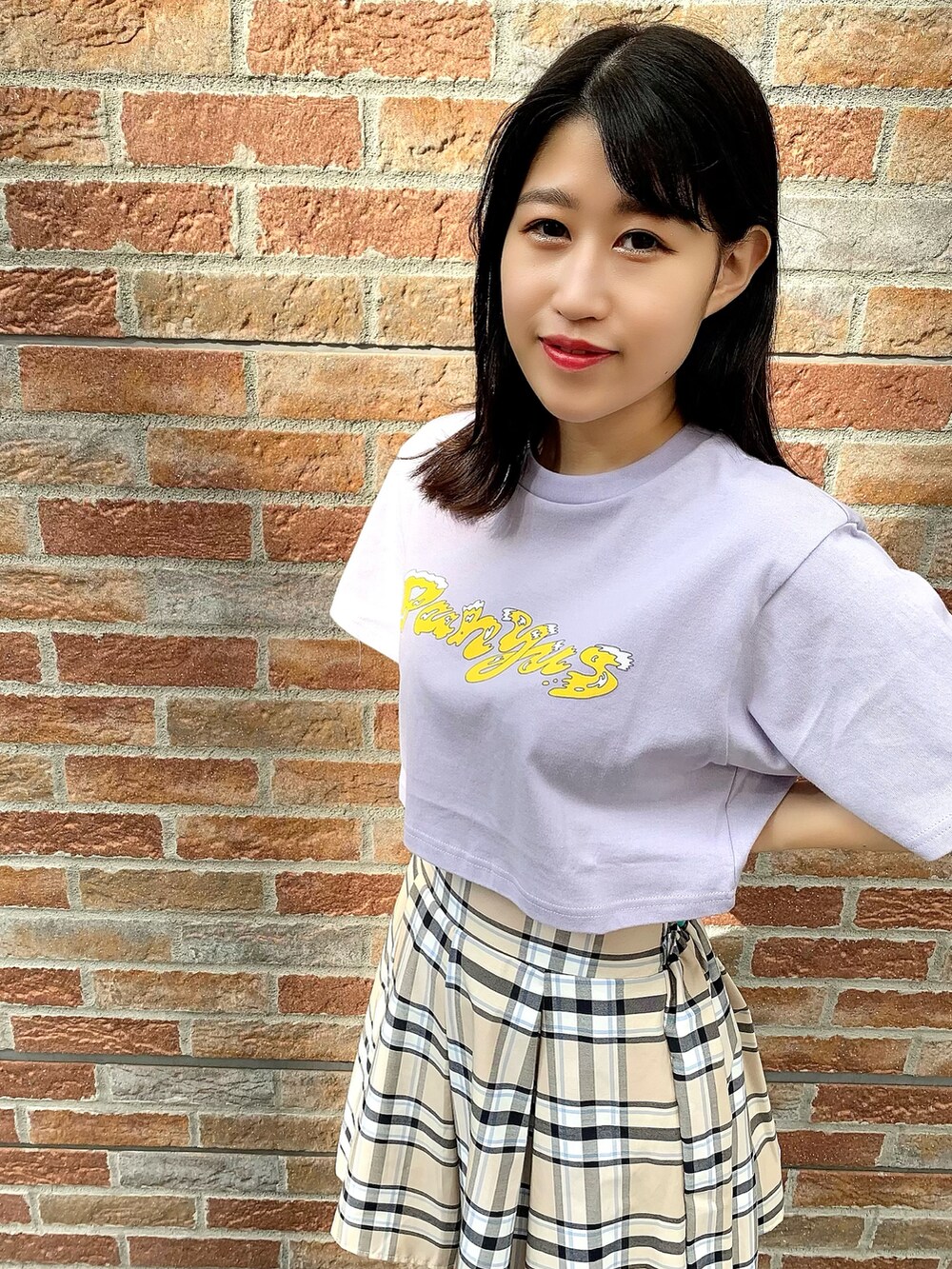 ベージュ系のスカート、パープル系のTシャツ/カットソーを着用したレディースの夏コーディネートの2枚目の写真