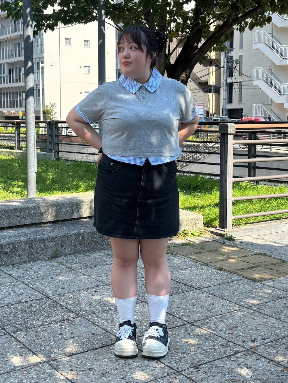 ブラック系のデニムスカート、グレー系のTシャツ/カットソーを着用したレディースの夏コーディネートの3枚目の写真