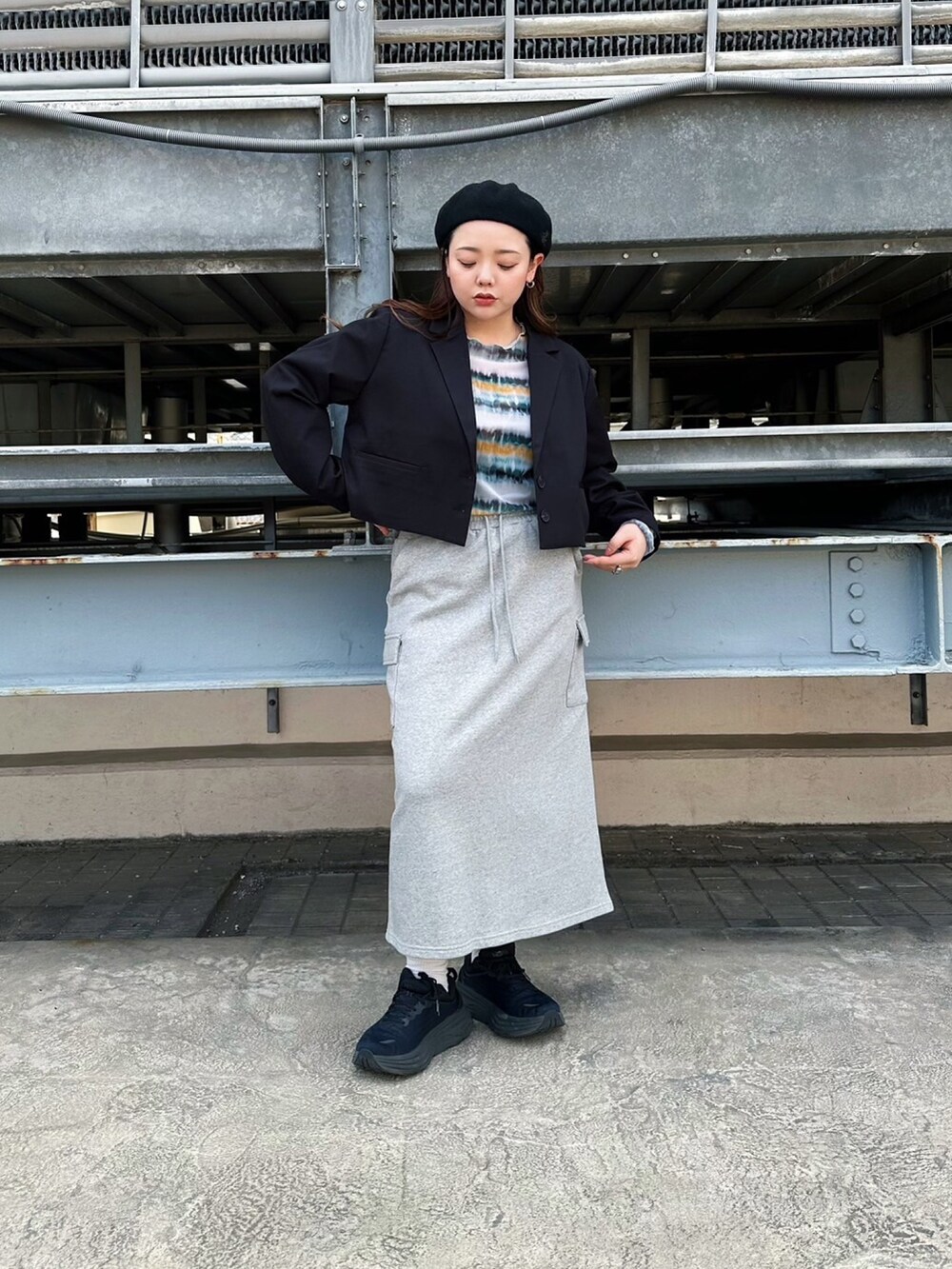 グレー系のスカート、ブラック系のテーラードジャケット、グリーン系のTシャツ/カットソーを着用したレディースの春コーディネートの2枚目の写真