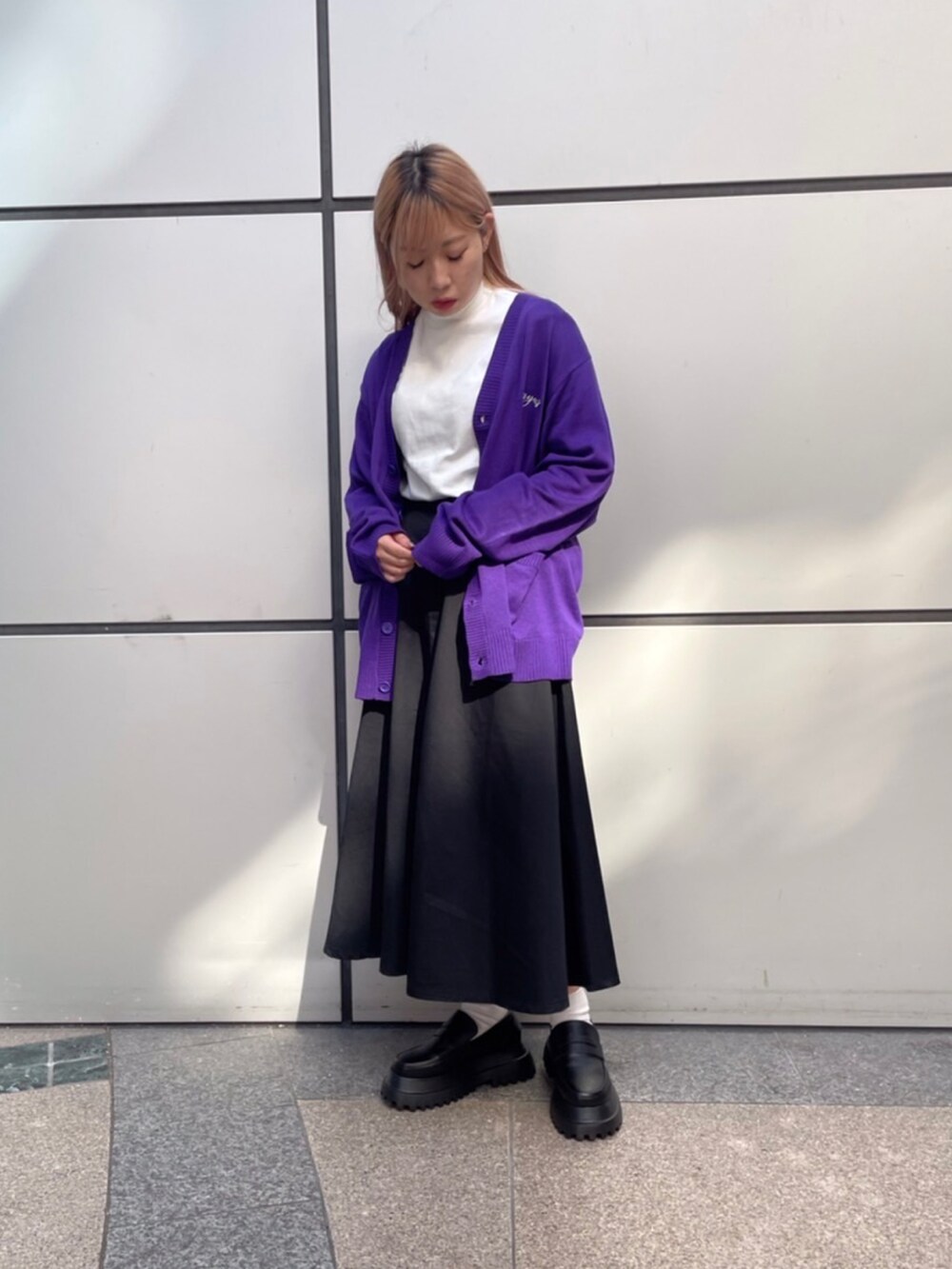 ブラック系のローファー、パープル系のカーディガン/ボレロ、ブラック系のスカートを着用したレディースの秋コーディネートの2枚目の写真