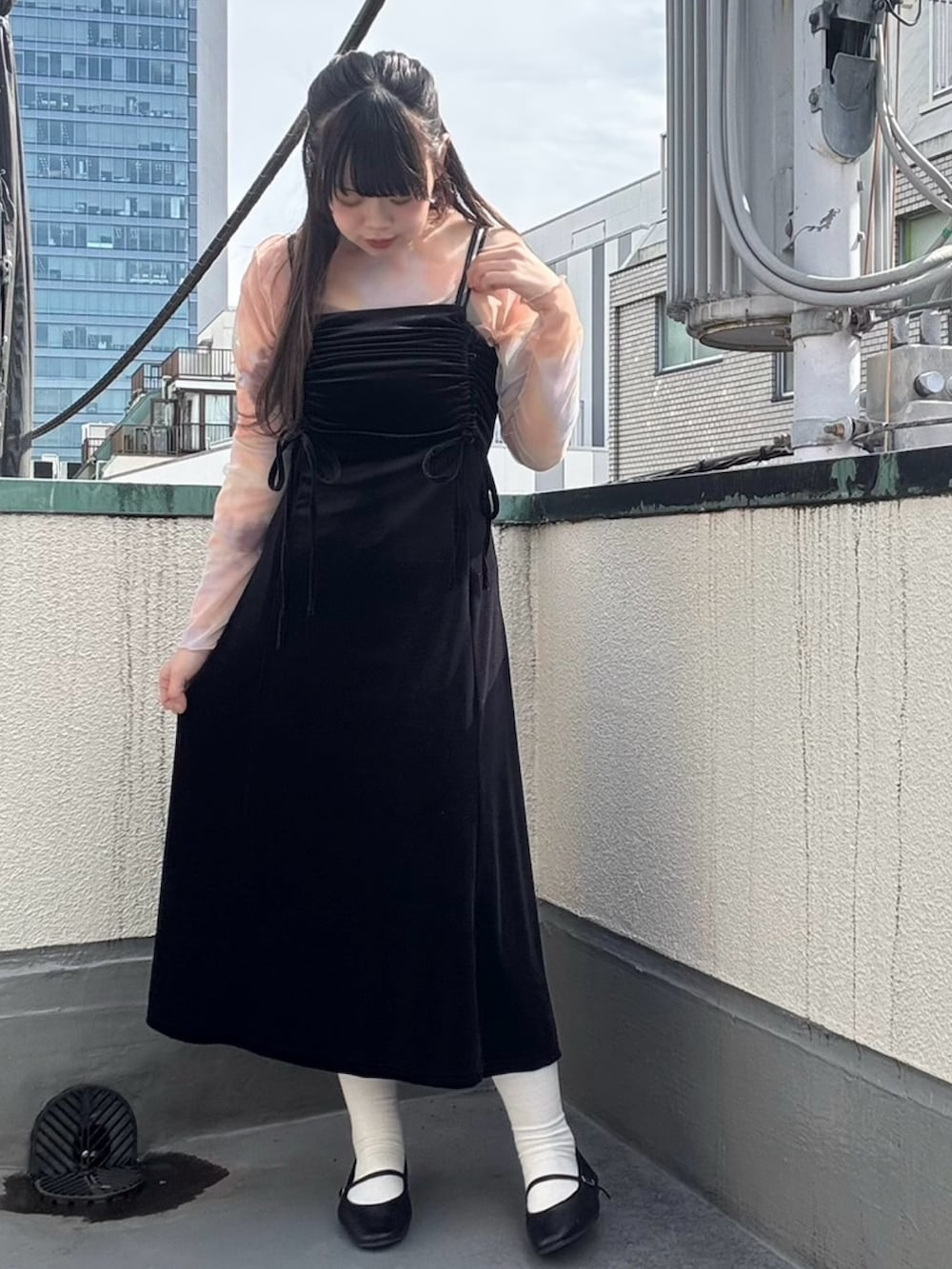 ブラック系のワンピース、オレンジ系のTシャツ/カットソーを着用したレディースの春コーディネートの3枚目の写真