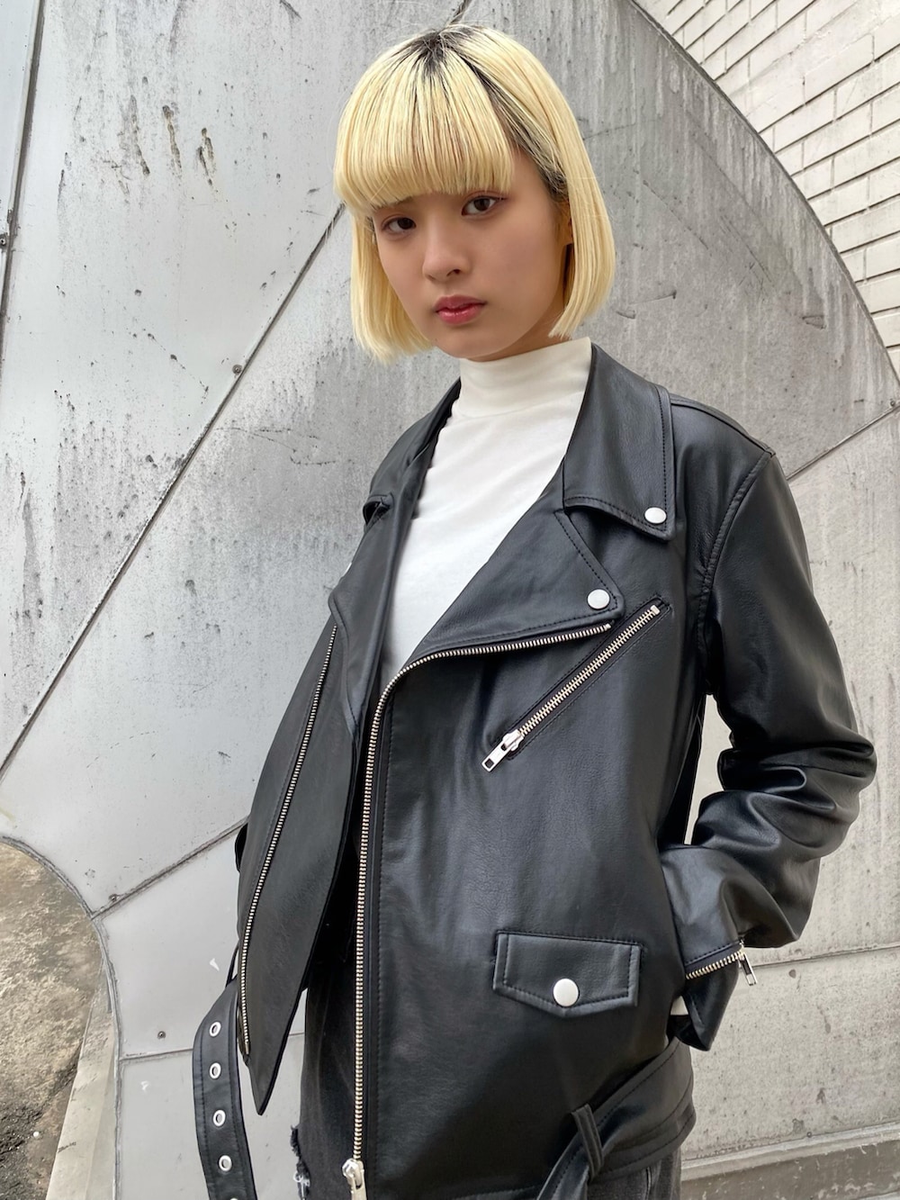 ホワイト系のTシャツ/カットソー、ブラック系のライダースジャケット、ブラック系のデニムパンツを着用したレディースの冬コーディネートの2枚目の写真