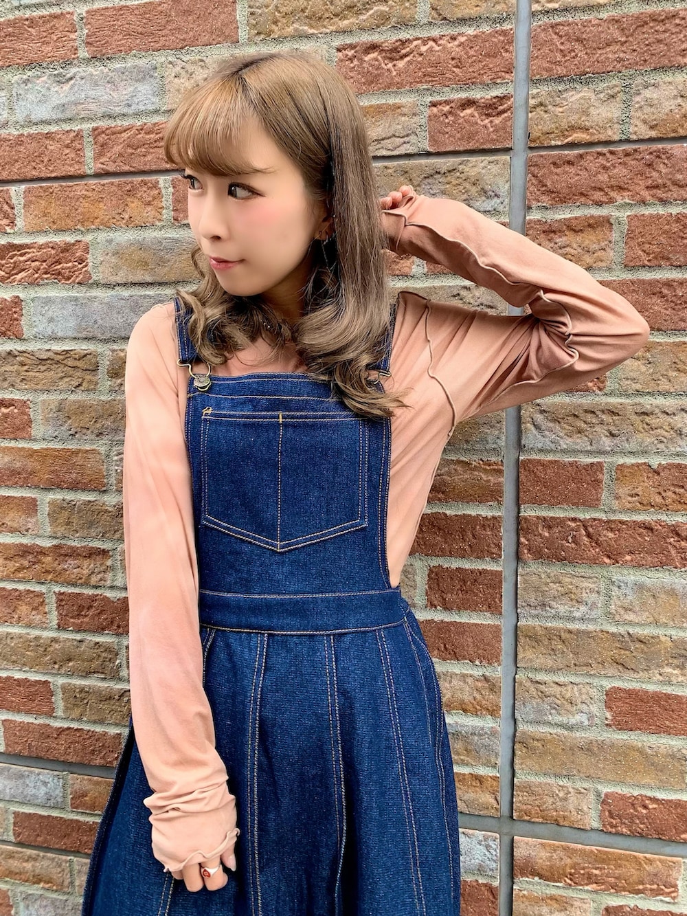 ブルー系のジャンパースカート、ブラック系のドレスシューズ、ブラウン系のTシャツ/カットソーを着用したレディースの秋コーディネートの3枚目の写真