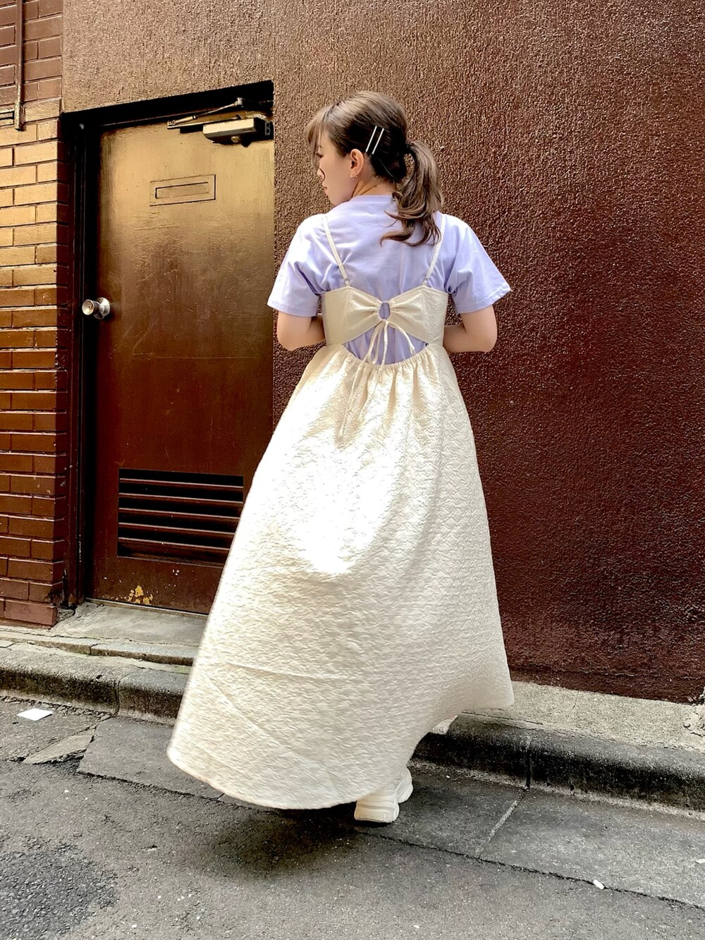 ホワイト系のワンピース、パープル系のTシャツ/カットソーを着用したレディースの春コーディネートの2枚目の写真