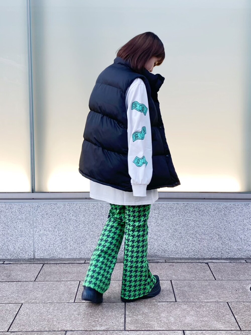 グリーン系のその他パンツ、ブラック系のダウンベスト、ホワイト系のTシャツ/カットソーを着用したレディースの冬コーディネートの3枚目の写真