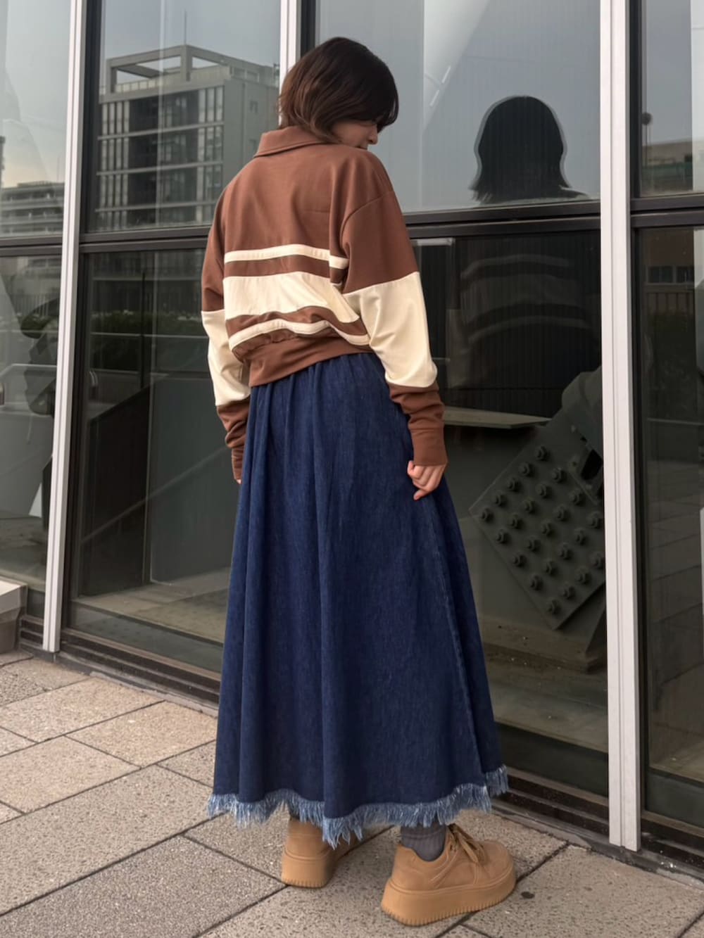 ブルー系のスカート、ブラウン系のスウェットを着用したレディースの春コーディネートの5枚目の写真