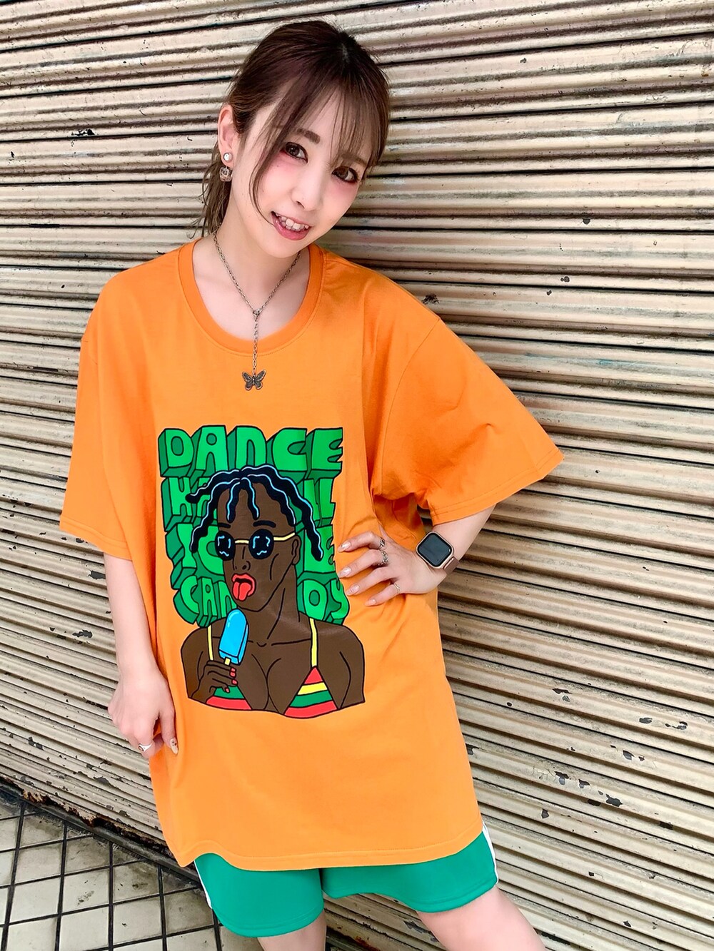 オレンジ系のTシャツ/カットソー、グリーン系のその他パンツ、ブラック系のブーツを着用したレディースの夏コーディネートの2枚目の写真