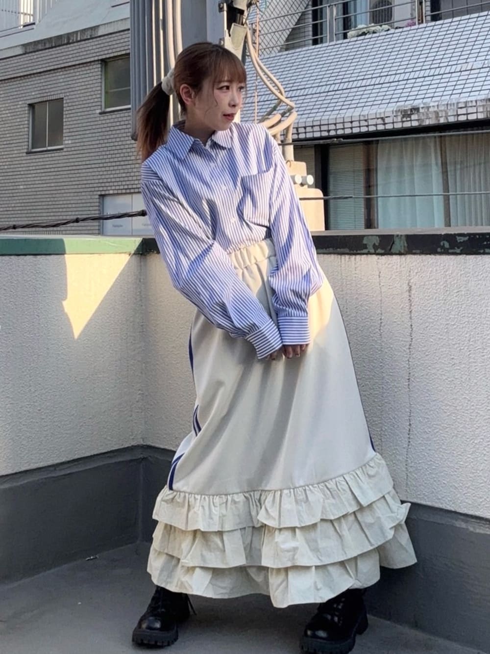 ホワイト系のスカート、ブルー系のシャツ/ブラウスを着用したレディースの春コーディネートの2枚目の写真