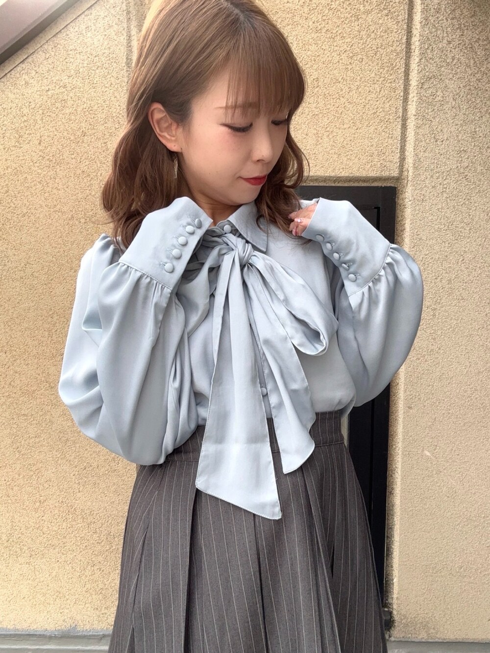 ブルー系のシャツ/ブラウス、グレー系のスカートを着用したレディースの春コーディネートの2枚目の写真