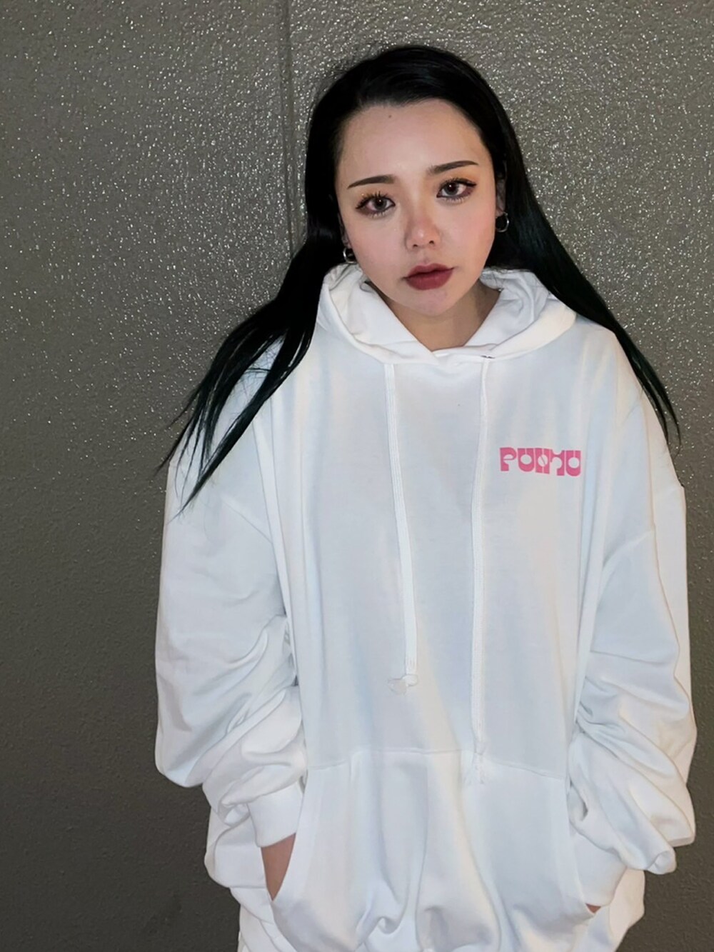 ホワイト系のパーカー、ホワイト系のスカート、ホワイト系のスニーカーを着用したレディースの春コーディネートの3枚目の写真