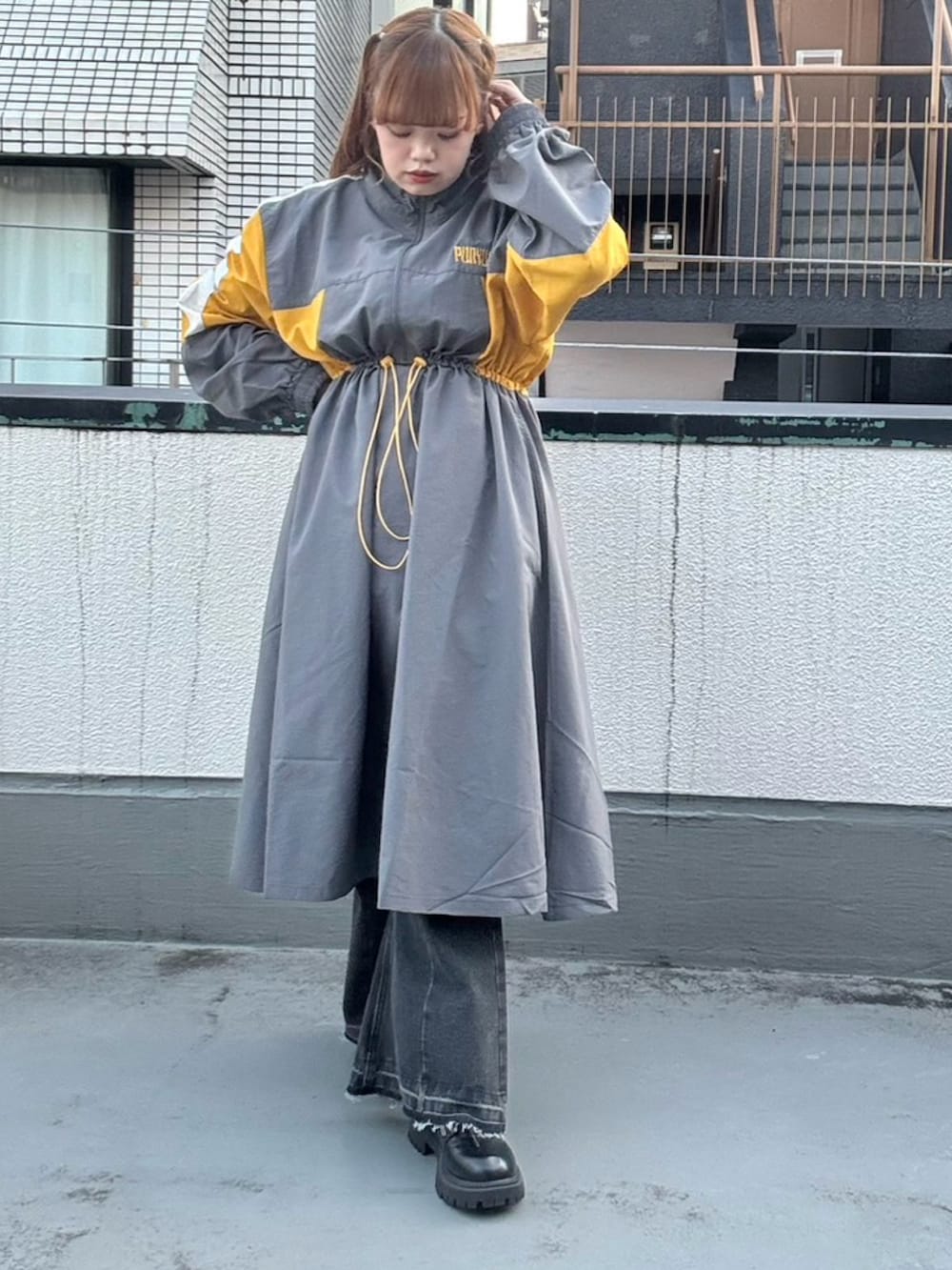 グレー系のワンピース、ブラック系のデニムパンツを着用したレディースの秋コーディネートの2枚目の写真