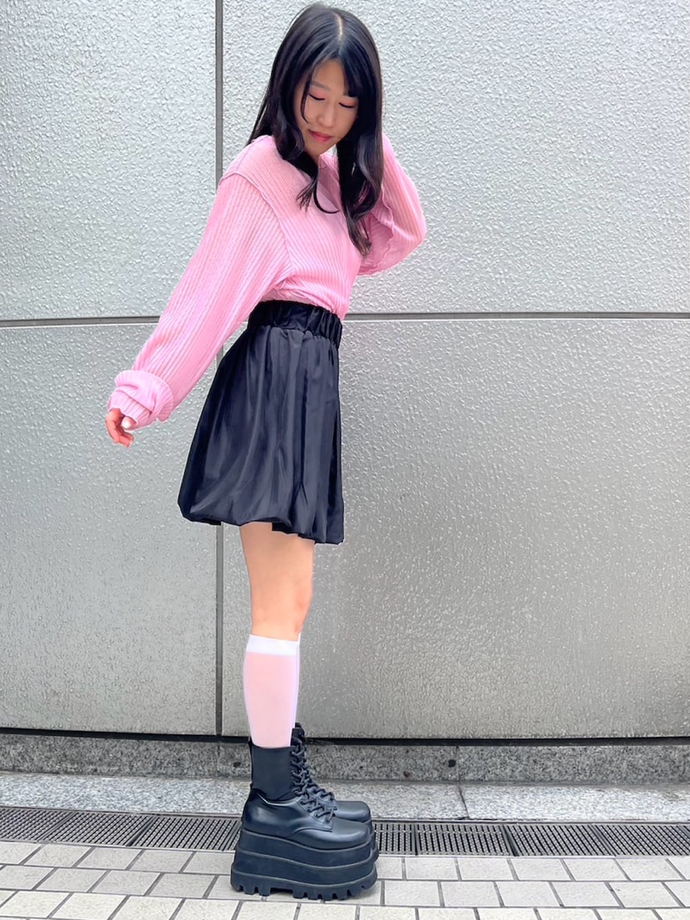 ブラック系のスカート、ピンク系のTシャツ/カットソーを着用したレディースの夏コーディネートの2枚目の写真