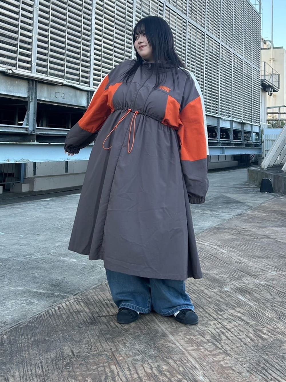 グレー系のワンピース、ブルー系のデニムパンツを着用したレディースの秋コーディネートの2枚目の写真