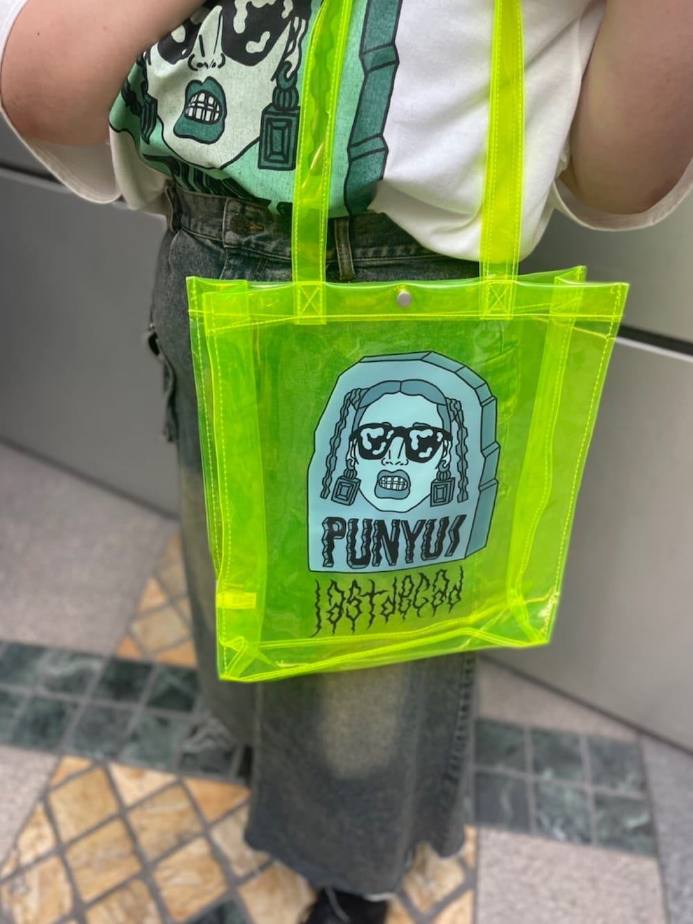 ホワイト系のTシャツ/カットソー、ブルー系のデニムスカート、イエロー系のトートバッグを着用したレディースの夏コーディネートの2枚目の写真