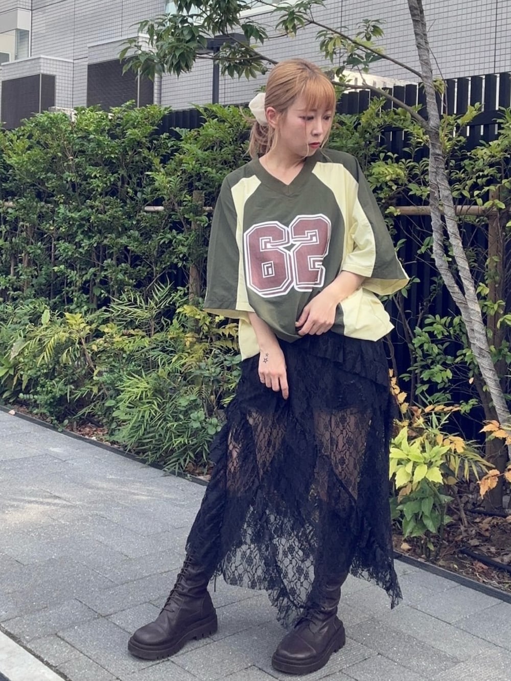 グリーン系のTシャツ/カットソー、ブラック系のスカートを着用したレディースの秋コーディネートの2枚目の写真