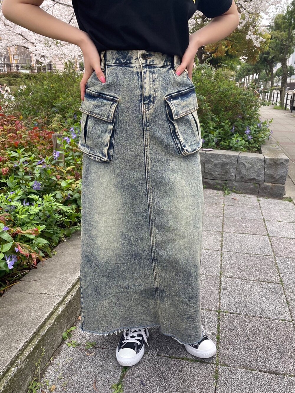 ブラック系のTシャツ/カットソー、ブルー系のデニムスカートを着用したレディースの春コーディネートの4枚目の写真