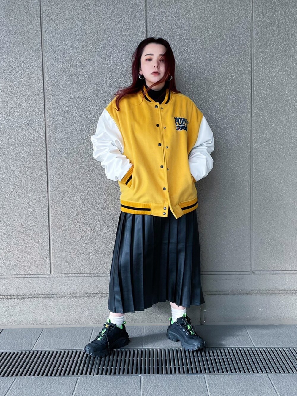 ブラック系のスカート、イエロー系のブルゾンを着用したレディースの冬コーディネートの2枚目の写真