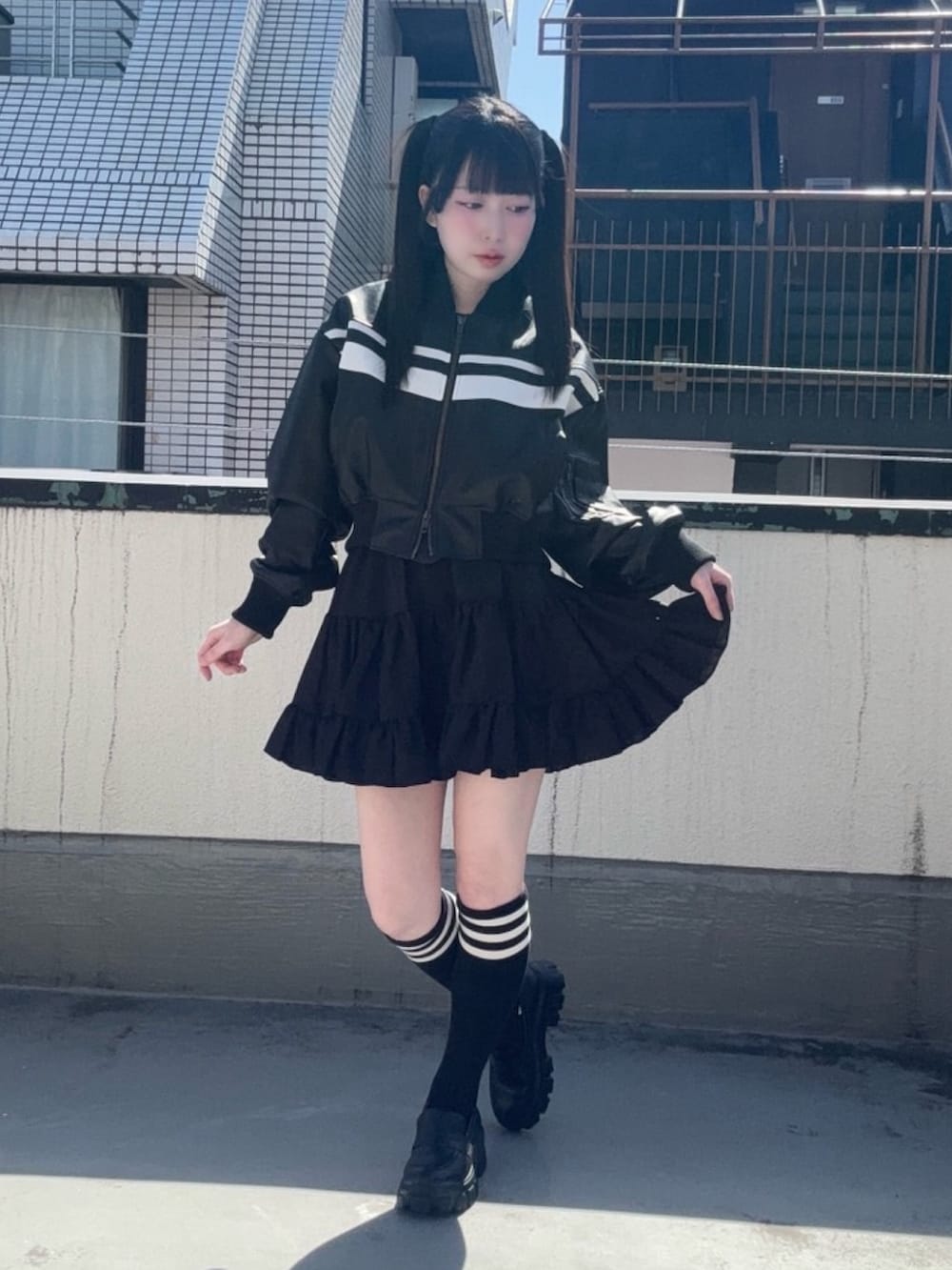 ブラック系のスカート、ブラック系のブルゾンを着用したレディースの春コーディネートの2枚目の写真