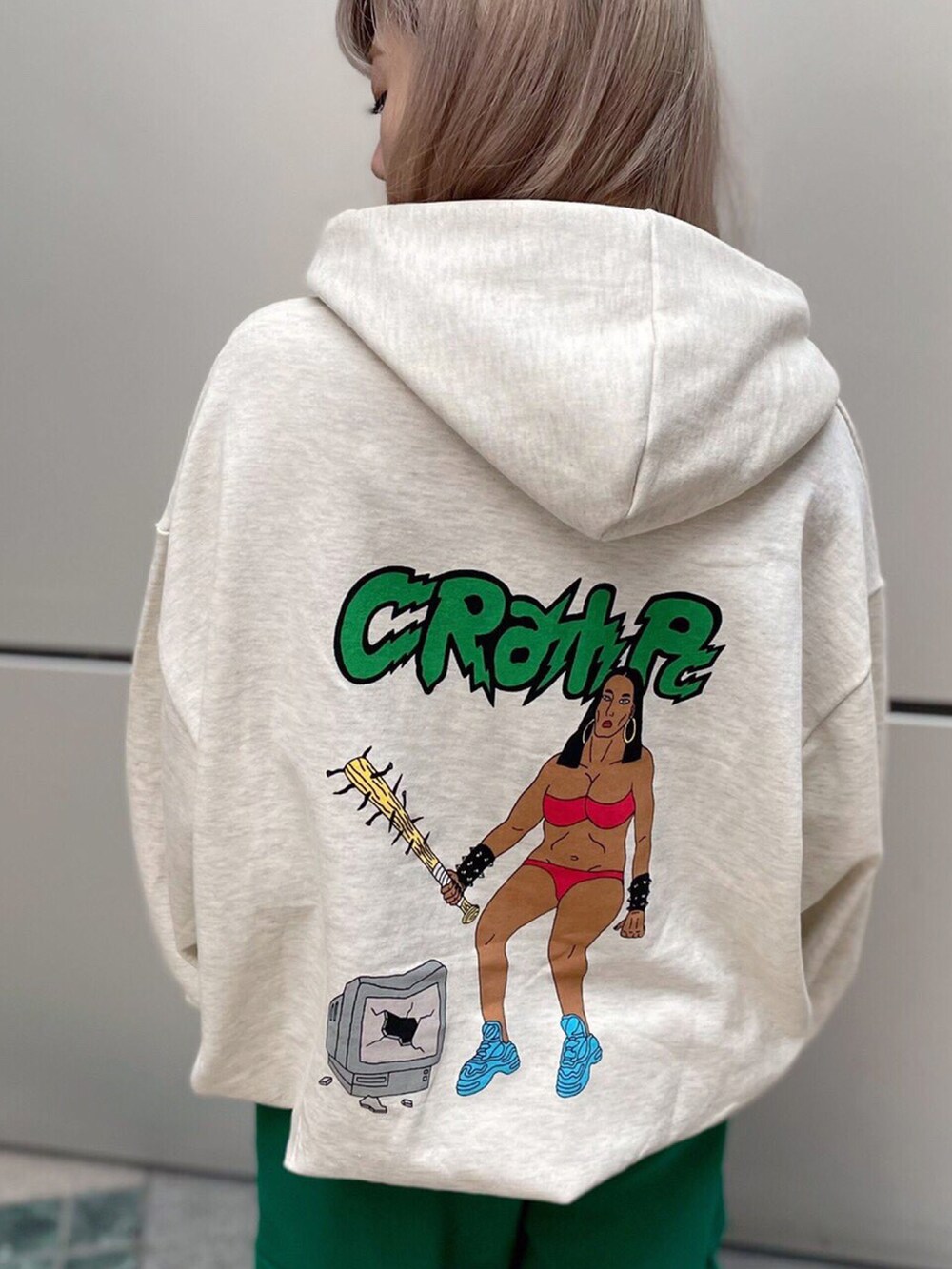 ベージュ系のパーカー、グリーン系のスウェットパンツを着用したレディースの春コーディネートの2枚目の写真