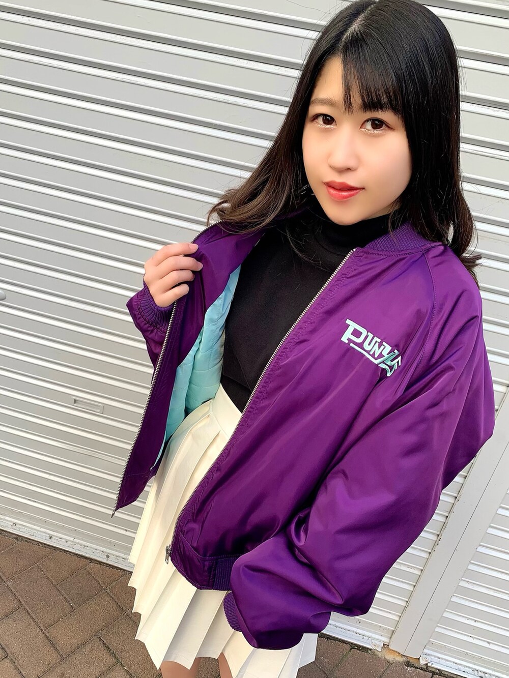 ブラック系のTシャツ/カットソー、パープル系のブルゾン、ホワイト系のスカートを着用したレディースの冬コーディネートの3枚目の写真