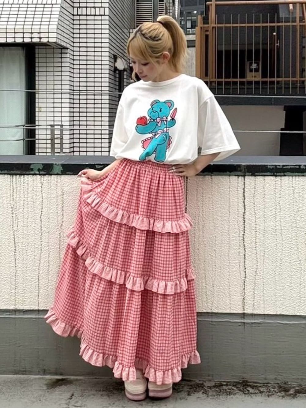 レッド系のスカート、ホワイト系のTシャツ/カットソーを着用したレディースの夏コーディネートの2枚目の写真