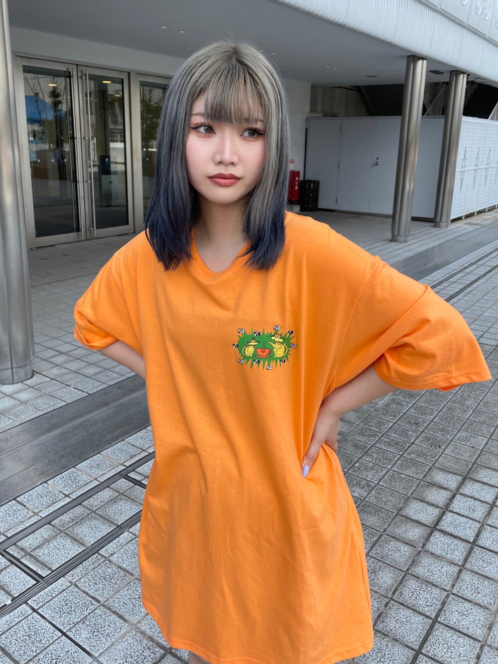 オレンジ系のTシャツ/カットソーを着用したレディースの夏コーディネートの3枚目の写真