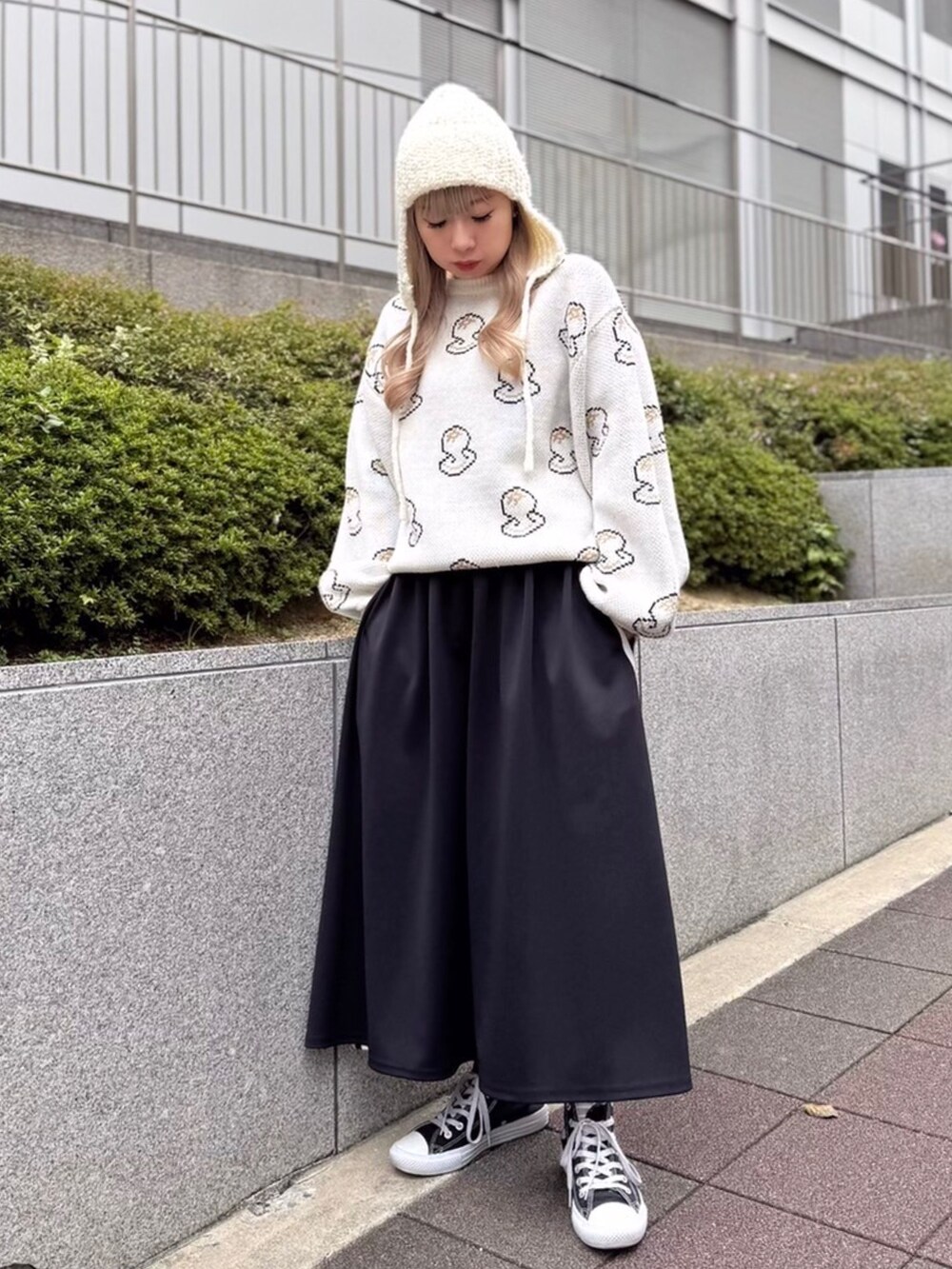 ホワイト系のニット/セーター、ブラック系のスカート、ホワイト系のニットキャップ/ビーニーを着用したレディースの冬コーディネートの2枚目の写真