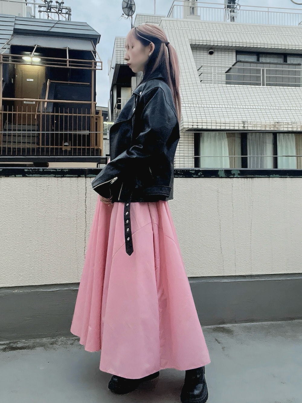 ピンク系のスカート、ブラック系のライダースジャケットを着用したレディースの秋コーディネートの3枚目の写真