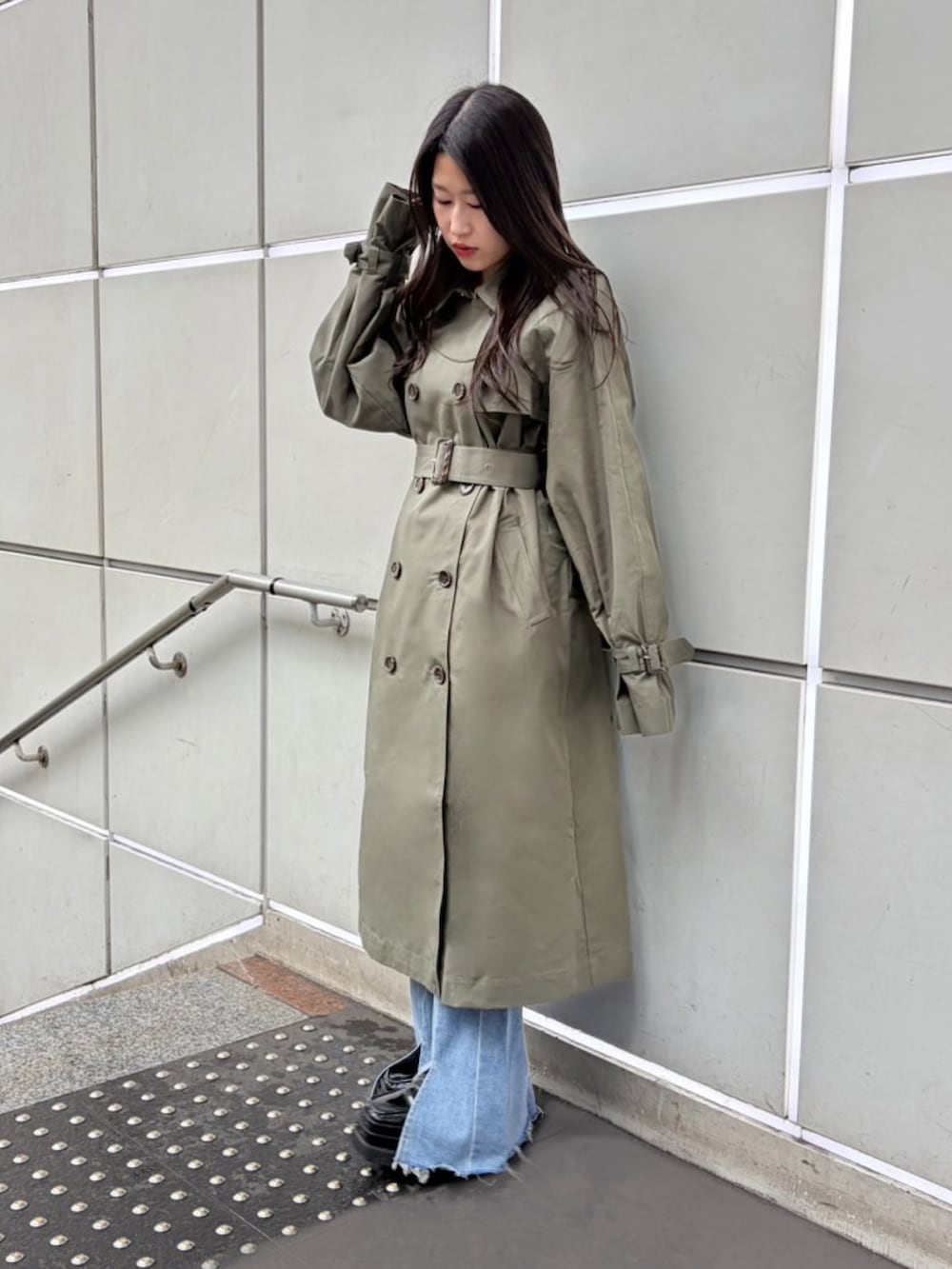 グリーン系のトレンチコート、ブルー系のデニムパンツ、ホワイト系のTシャツ/カットソーを着用したレディースの春コーディネートの4枚目の写真