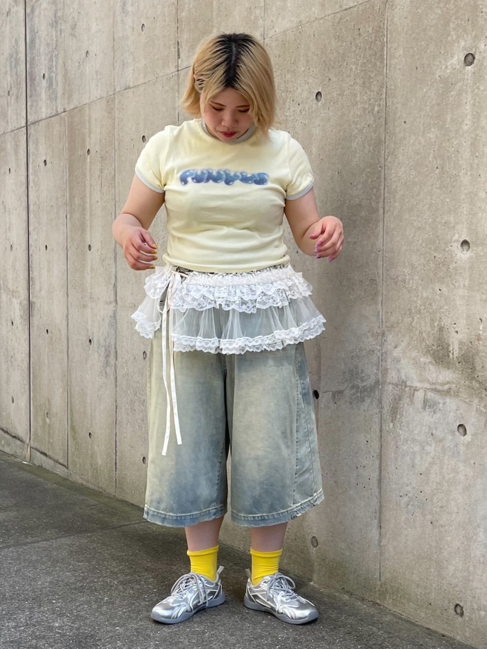 ブルー系のデニムパンツ、ホワイト系のスカート、イエロー系のTシャツ/カットソーを着用したレディースの夏コーディネートの2枚目の写真