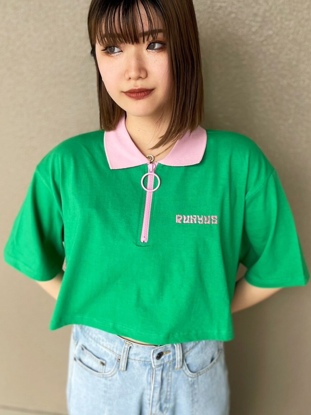 グリーン系のポロシャツ、ブルー系のデニムパンツ、ブラック系のサンダルを着用したレディースの春コーディネートの2枚目の写真