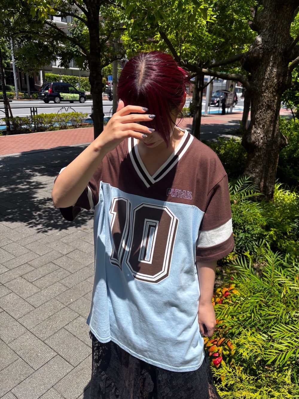 ブラウン系のTシャツ/カットソー、ブラック系のスカート、ブルー系のデニムパンツを着用したレディースの夏コーディネートの5枚目の写真