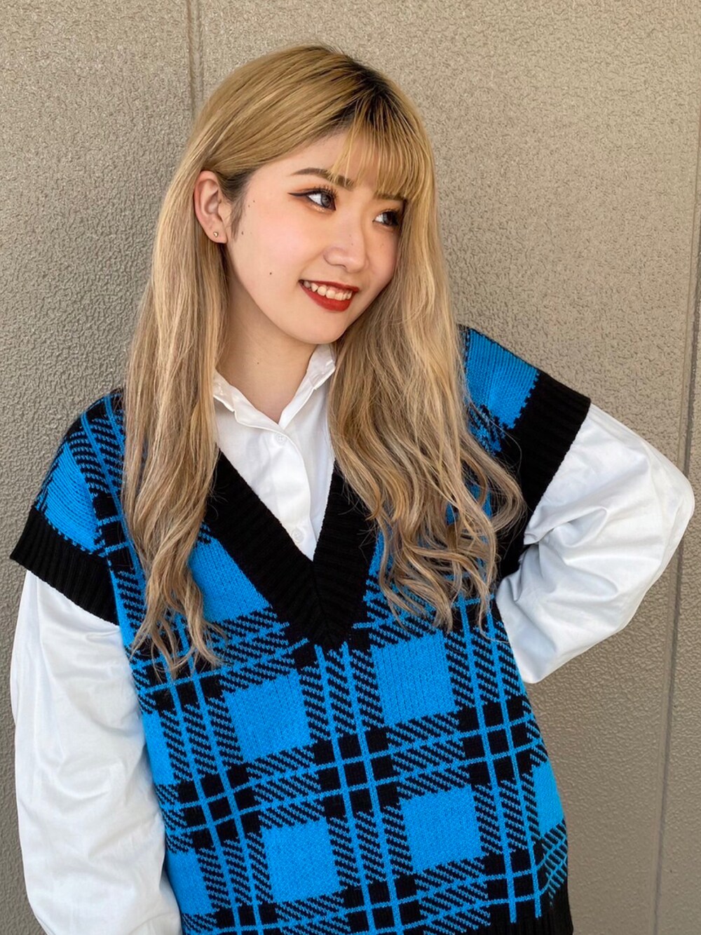 ブルー系のベスト、ホワイト系のシャツ/ブラウス、ホワイト系のスカートを着用したレディースの春コーディネートの2枚目の写真