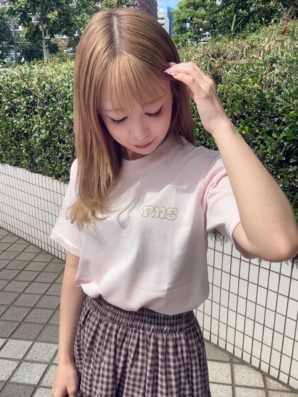 ブラウン系のスカート、ピンク系のTシャツ/カットソーを着用したレディースの夏コーディネートの4枚目の写真