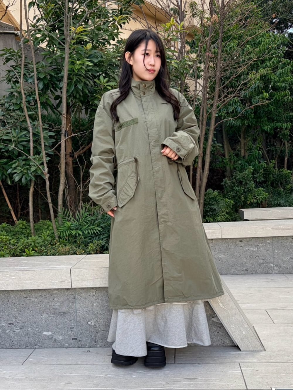 イエロー系のTシャツ/カットソー、グリーン系のモッズコート、グレー系のスカートを着用したレディースの冬コーディネートの4枚目の写真