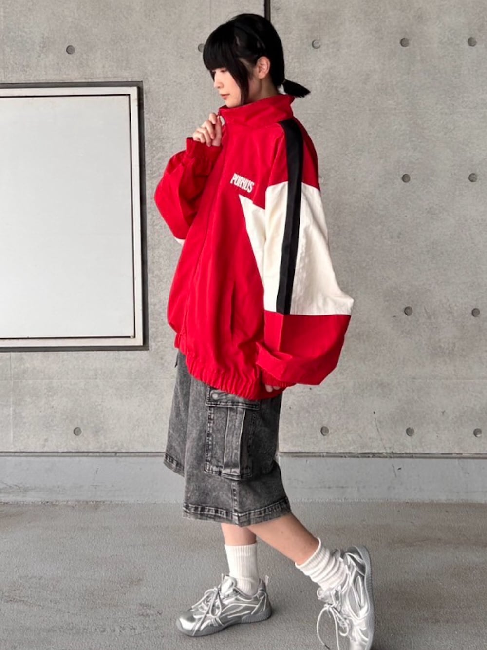 レッド系のナイロンジャケット、ブラック系のデニムパンツを着用したレディースの秋コーディネートの4枚目の写真