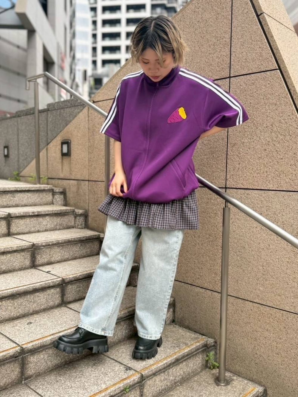 パープル系のジャージ、ブルー系のスカート、ブルー系のデニムパンツを着用したレディースの春コーディネートの2枚目の写真