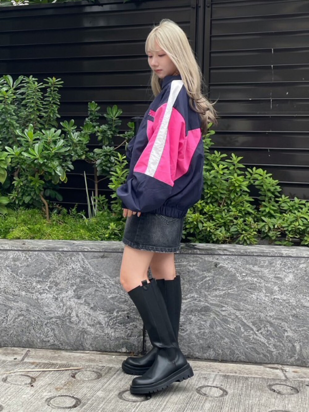 ブルー系のナイロンジャケット、ブラック系のデニムスカートを着用したレディースの秋コーディネートの3枚目の写真