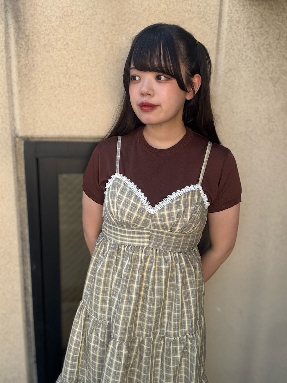 イエロー系のワンピース、ブラウン系のニット/セーターを着用したレディースの夏コーディネートの8枚目の写真